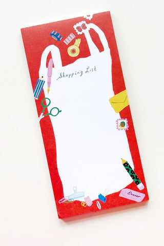 A red notepad with a white shopping bag illustration and colorful stationery doodles, labeled 'Shopping List' on a white background.