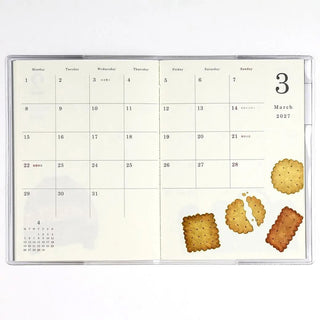 Monthly planner page for March 2027 with date grid and cookie illustrations