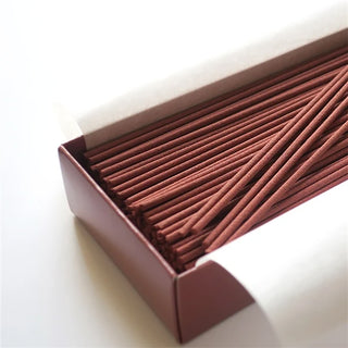 Close-up of brown incense sticks laid in open rectangular box
