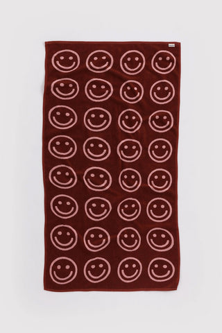 Maroon bath towel with repeating smiley faces in light outline