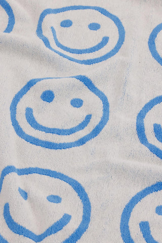 Light gray bath towel close-up with blue outlined smiley faces