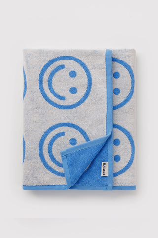 Folded bath towel with blue happy face print and stitched blue border