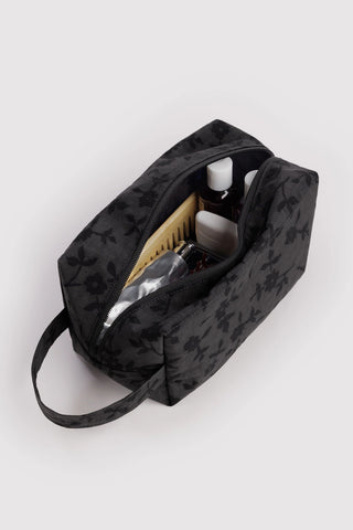 Charcoal floral toiletry bag open with organizer pocket, holds bottles and toiletries