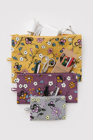 Floral flat pouch set with zipper, one yellow pouch open holding pens and markers