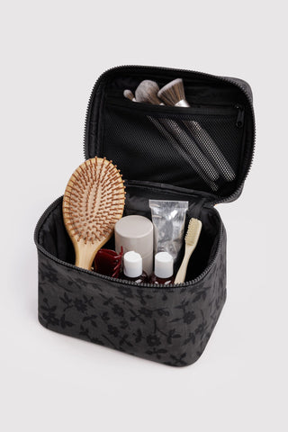 Open charcoal floral cosmetic case with interior mesh pockets and zip