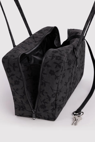 Charcoal nylon bowler bag opened with zip top, visible interior and floral pattern.