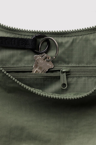 Olive nylon bag close-up: top zipper and D-ring key clip on flap