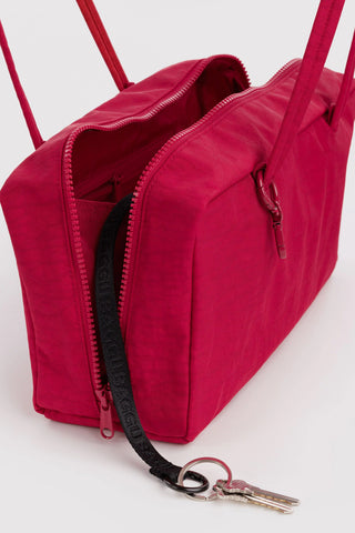 Red nylon bowler bag close-up with open zipper, interior pocket, and key clip