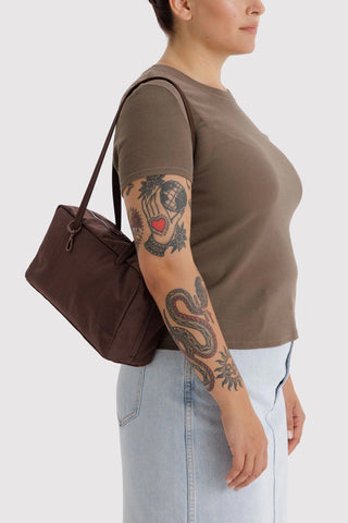 Coffee-brown nylon bowler bag carried by top handles, side view