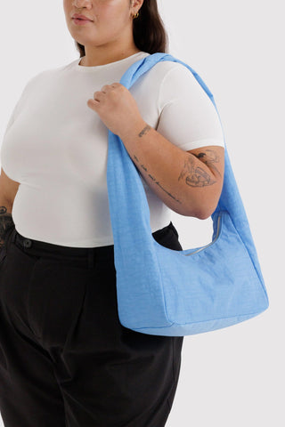 Person holding a blue bag against a white background