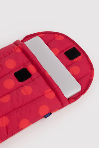 Open red polka-dot laptop sleeve with quilted padding and black hook-and-loop tabs.