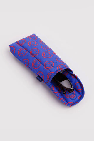 BAGGU mini puffy glasses sleeve, blue with red smiley pattern, glasses visible inside