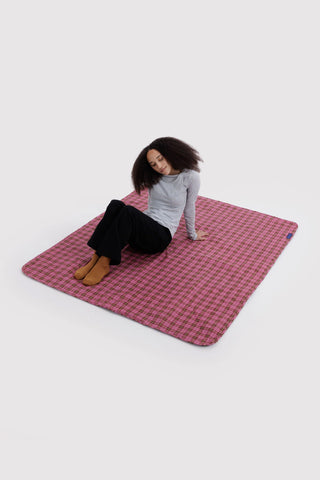 Puffy picnic blanket in pink and green tartan, laid flat