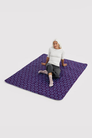 Indigo patterned puffy picnic blanket laid flat, repeating smiley icons