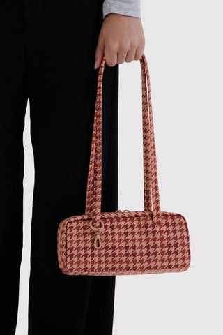 Small houndstooth bowler bag in tan and maroon, held by two top handles