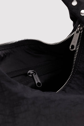 Black nylon bag interior showing zipper and studded trim at the opening