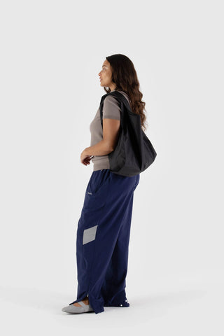Black BAGGU tote bag with short handles, side view on a standing model