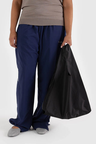 Black BAGGU tote bag with short handles, carried by the handles