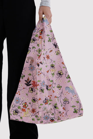 Light pink BAGGU tote with colorful floral and creatures print, carried by long strap handles