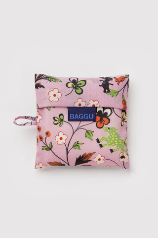 Folded light pink BAGGU standard tote with colorful floral and creatures print, front logo panel