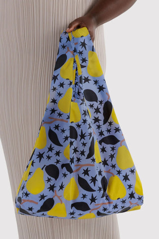 BAGGU tote bag with yellow pear and star print, held by the handle