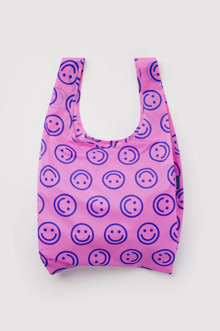 Pink reusable tote bag with smiley face pattern and long handles