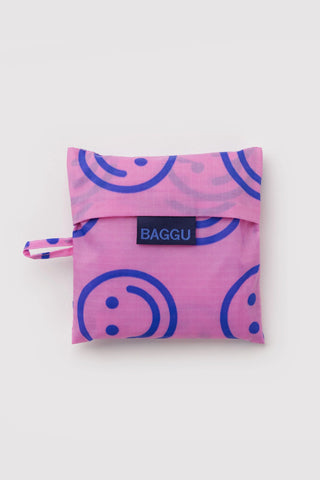 BAGGU tote bag folded into a small pouch with blue smiley logo label