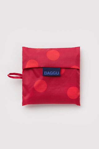 BAGGU red polka-dot tote bag folded into small pouch with logo tag