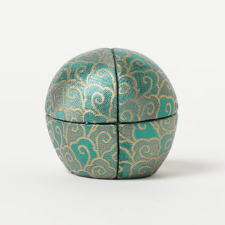 Back of green fabric daruma with gold accents 