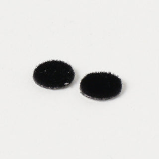 Two felt eyes for the daruma on a white background