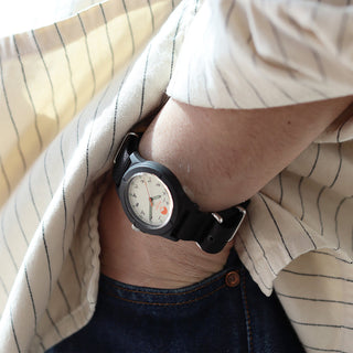 Person wearing a watch with a striped shirt and jeans