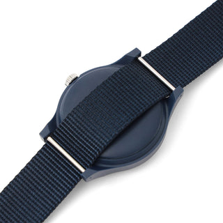 Navy blue watch with a textured strap on a white background