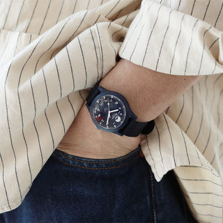 Person wearing navy wristwatch with their hand in pocket