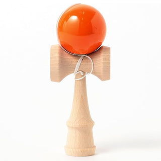 Wooden kendama with an orange ball on a white background