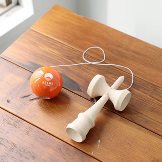 Wooden toy with orange ball on a wooden surface