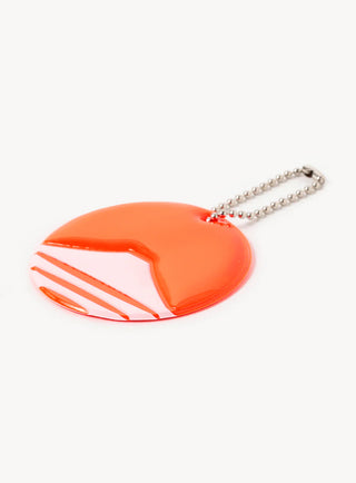 Round keychain laying flat with a mountain logo on a white background