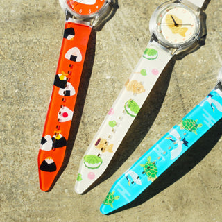Three colorful wristwatches with designs on a textured surface