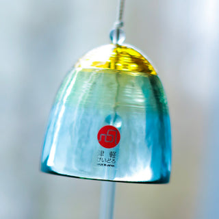 Hanging wind chime with a blue and yellow design on a blurred background