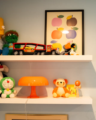 Shelves with toys and a colorful framed picture on a light gray wall.