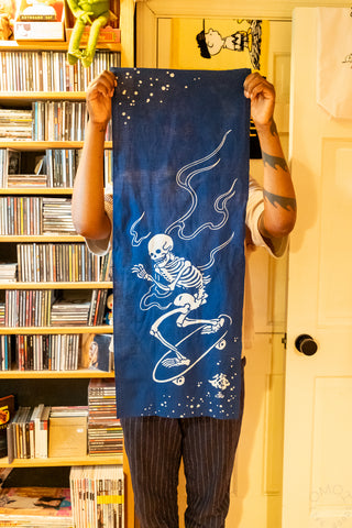 Person holding navy cloth in front of bookshelf
