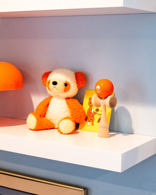 Plush toy and wooden kendama on a shelf 