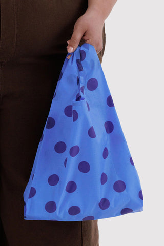 Baby BAGGU reusable tote bag held in hand, blue with dark purple polka dots