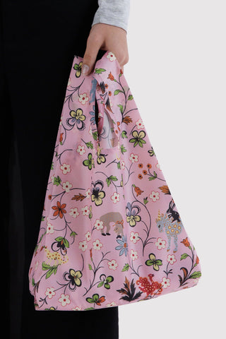 Pink BAGGU tote in hand, colorful floral and animal creature pattern