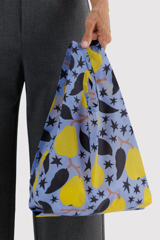 Baby BAGGU tote bag held by hand, navy with yellow pear and star print