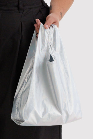 Person holding a opalescent reusable bag on a plain background