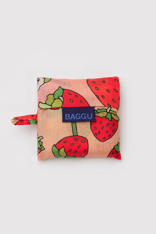 Baby BAGGU strawberry blossom pouch with blue BAGGU logo patch and zipper pull.