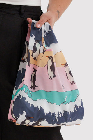 Bag with penguin design held by a person against a white background
