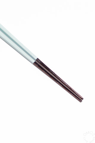 Close up of light blue bambooo chopsticks on a white background