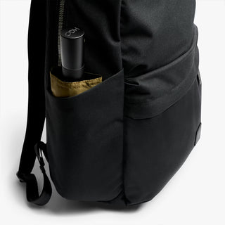 Black backpack with an umbrella inside on a white background