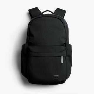 A black backpack with a front zippered pocket and side pockets, shown against a light gray background.